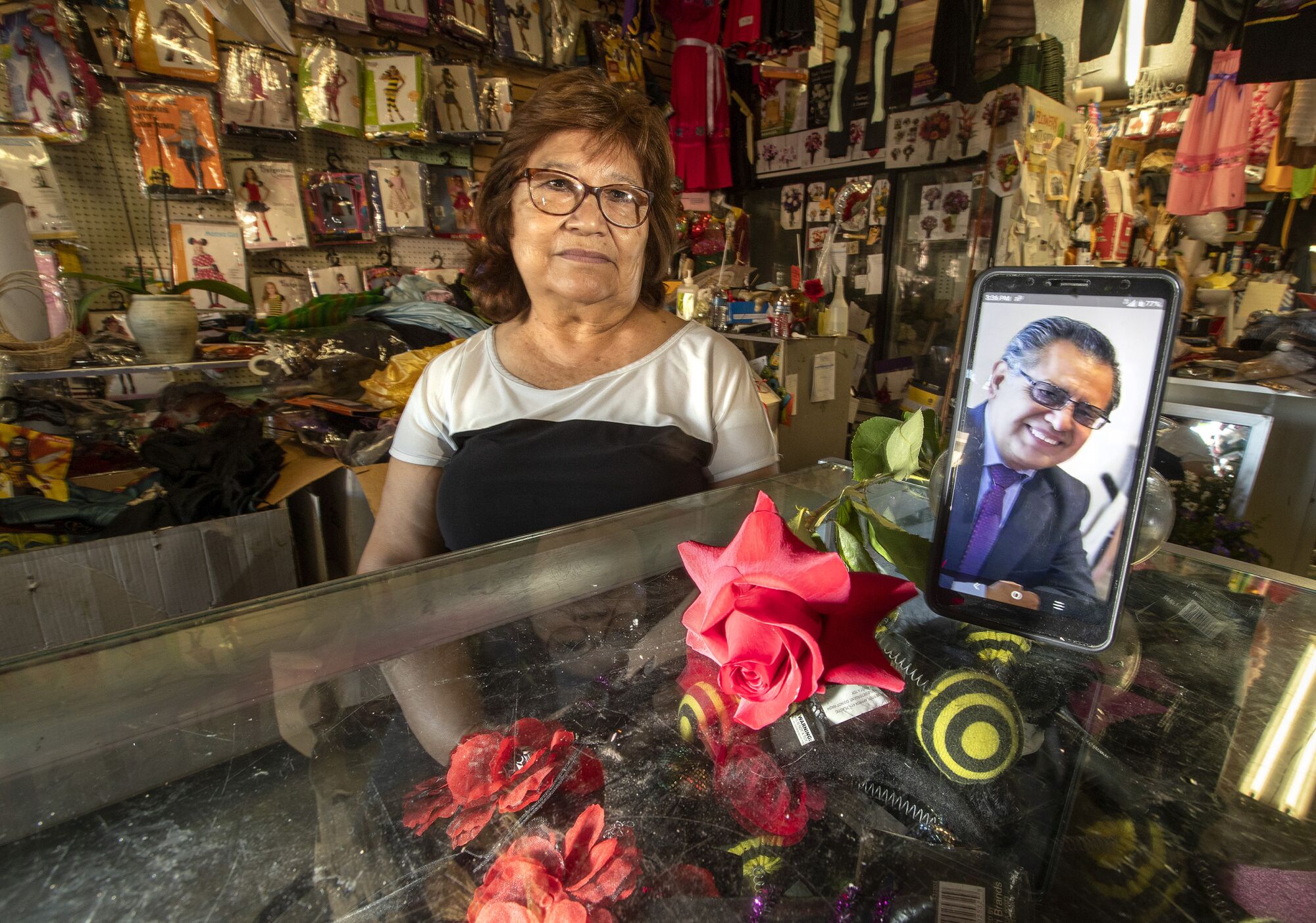 Martha Jimenez sits in her shop alongside a photo of her brother who died Oct. 8.