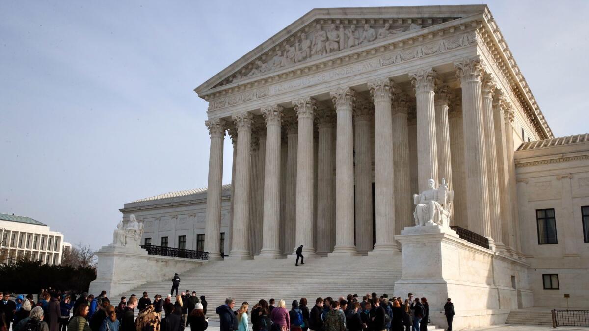 People stand in line to enter the Supreme Court in Washington on Dec. 4.