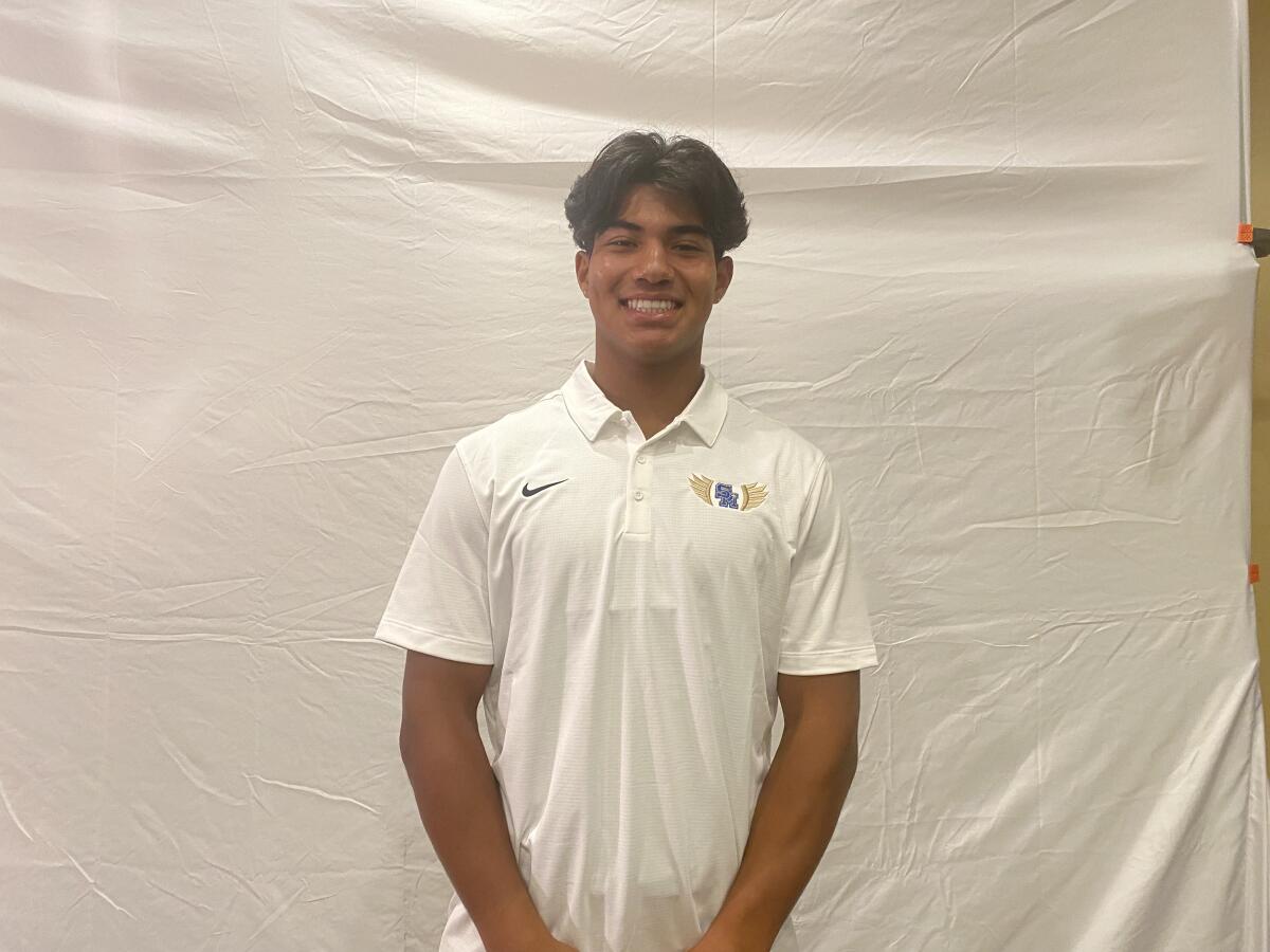 Niko Lopez poses and smiles in a white polo.