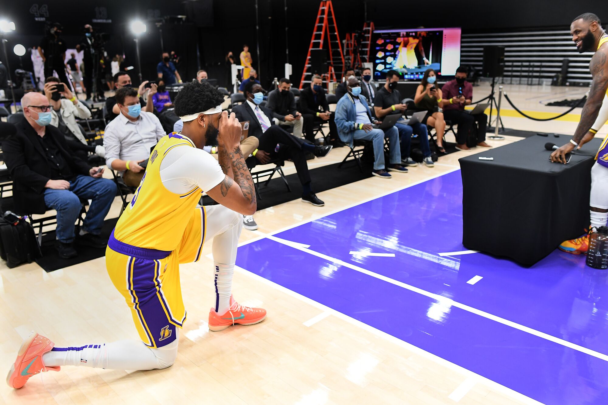 Lakers Anthony Davis takes pictures of LeBron James during an interview on media day.