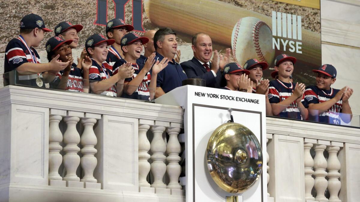 Members of the Mid Island Little League team from Staten Island, N.Y., applaud as their manager rings the New York Stock Exchange opening bell Aug. 31.
