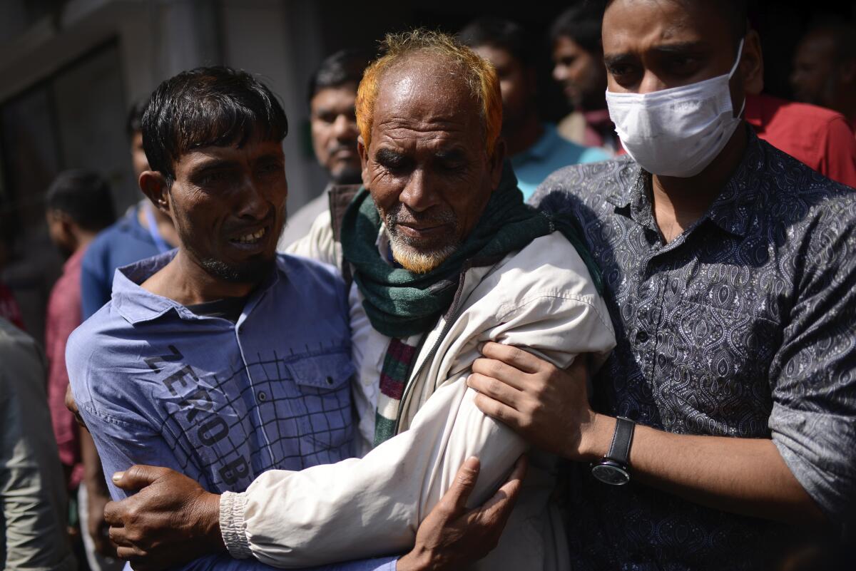 Family members of a victim of a fire that broke out at a commercial complex react in a hospital in Dhaka, Bangladesh.