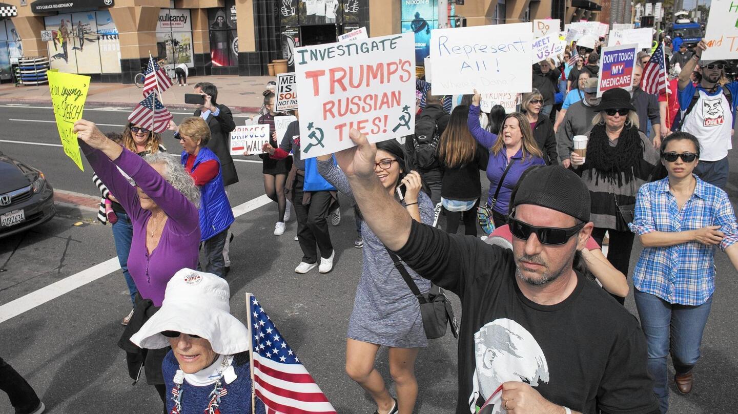 Protesters opposing Rep. Dana Rohrabacher's (R-Costa Mesa) support for President Trump and opposing Trump march down Main Street in Huntington Beach on Monday.