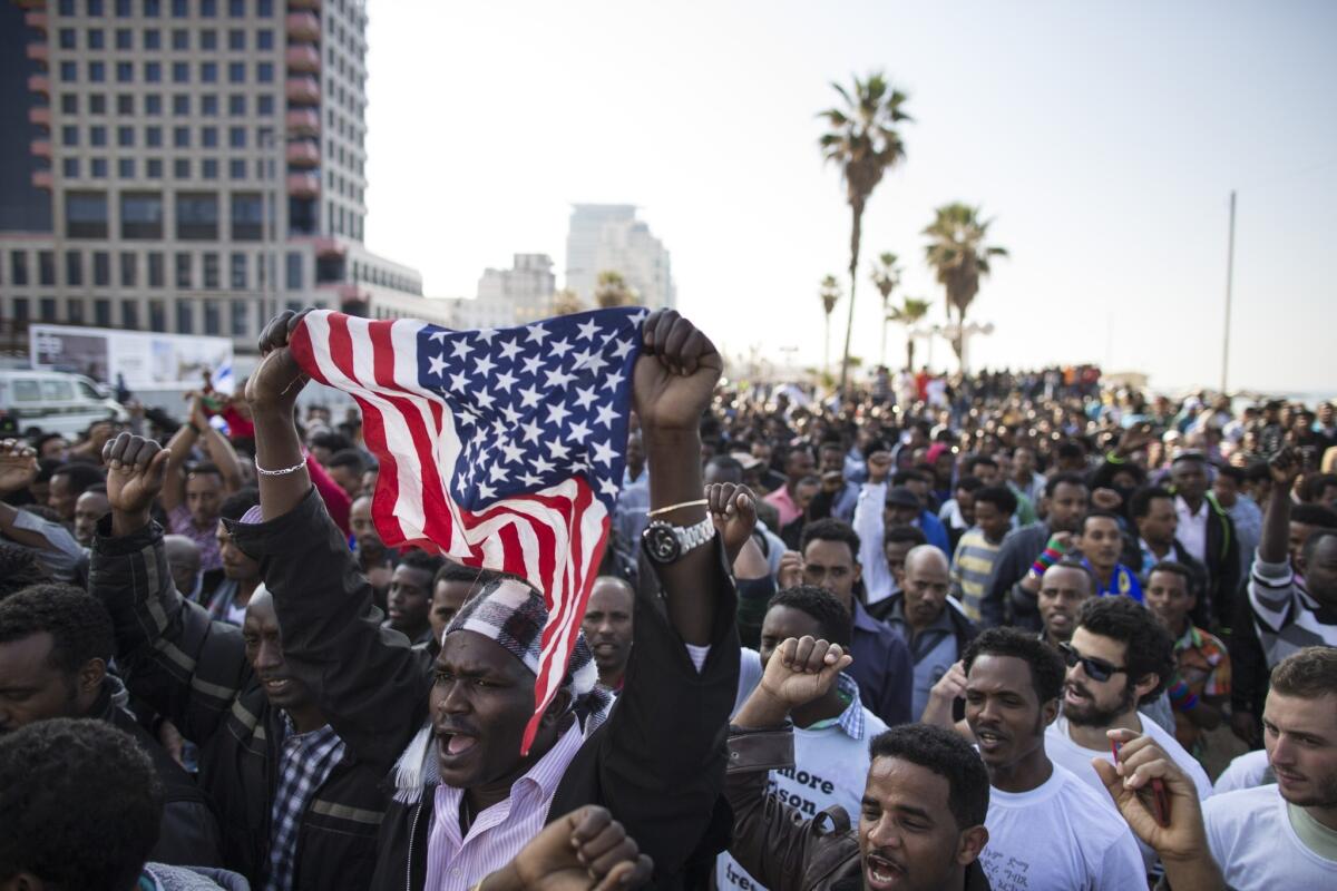 Thousands of African immigrants rally in front of the American Embassy in Tel Aviv on Monday, demanding international pressure on Israel to overturn a law allowing authorities to keep them in detention while asylum requests are processed.