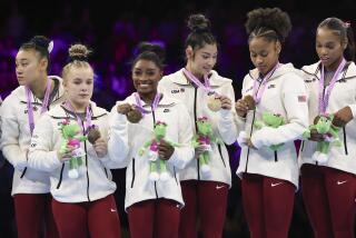 Team USA look at their medals as Simone Biles smiles, third left, after the women's team final at the Artistic Gymnastics World Championships in Antwerp, Belgium, Wednesday, Oct. 4, 2023. (AP Photo/Geert vanden Wijngaert)