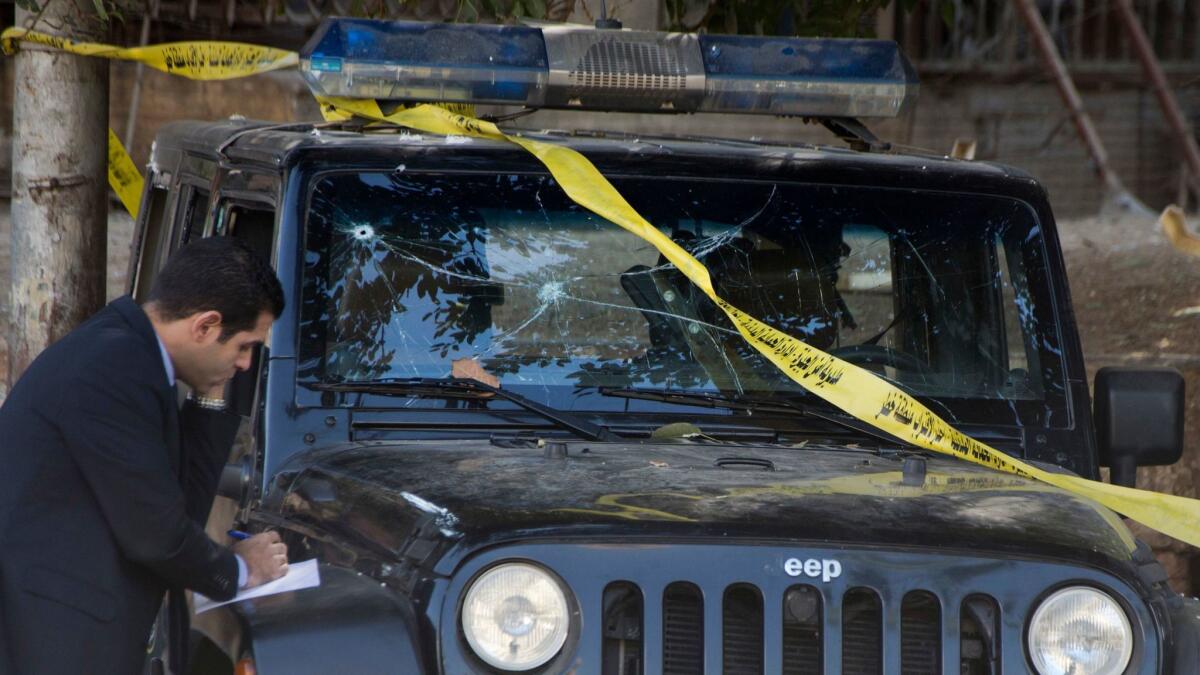 An Egyptian explosives expert takes note of damage to a police vehicle following an explosion in Cairo on Dec. 9.