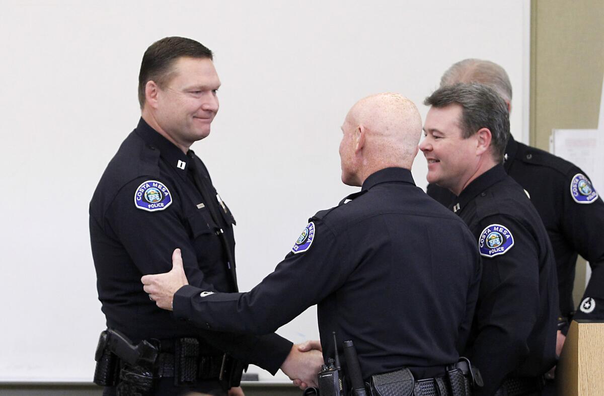 Rob Sharpnack, left, is congratulated in 2013 after being promoted to captain in the Costa Mesa Police Department. On Wednesday, Sharpnack was promoted to chief.