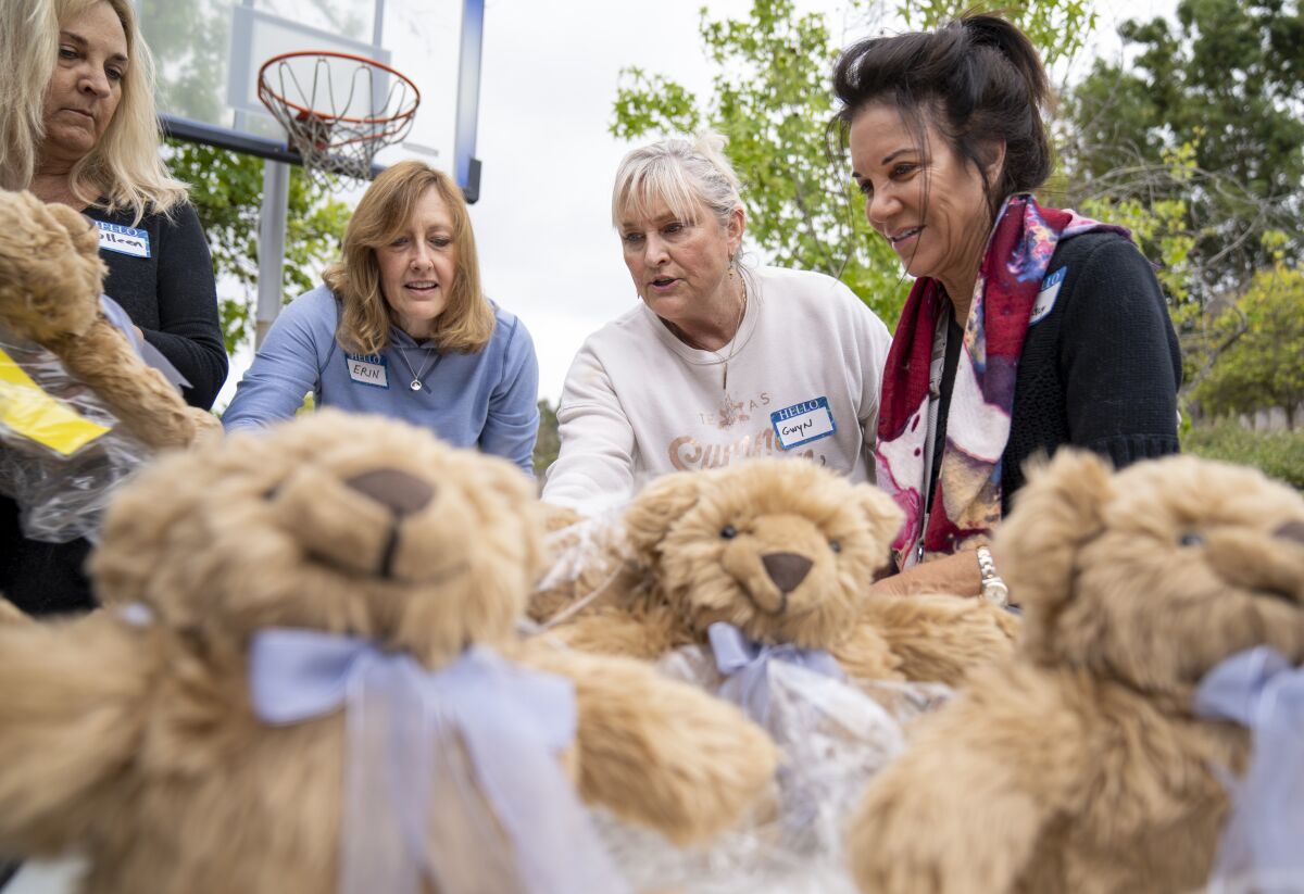 Volunteers prepare weighted therapeutic teddy bears for packing