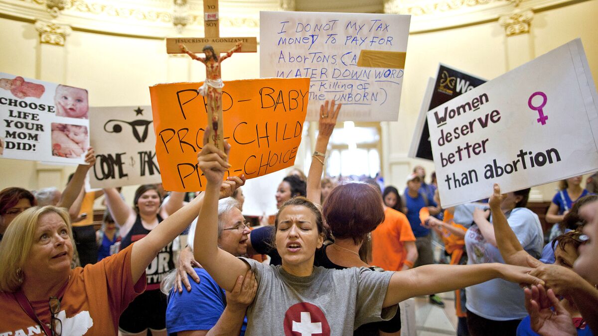 An antiabortion activist prays during a gathering of opponents and supporters of abortion rights at the Texas Capitol in Austin over the summer.