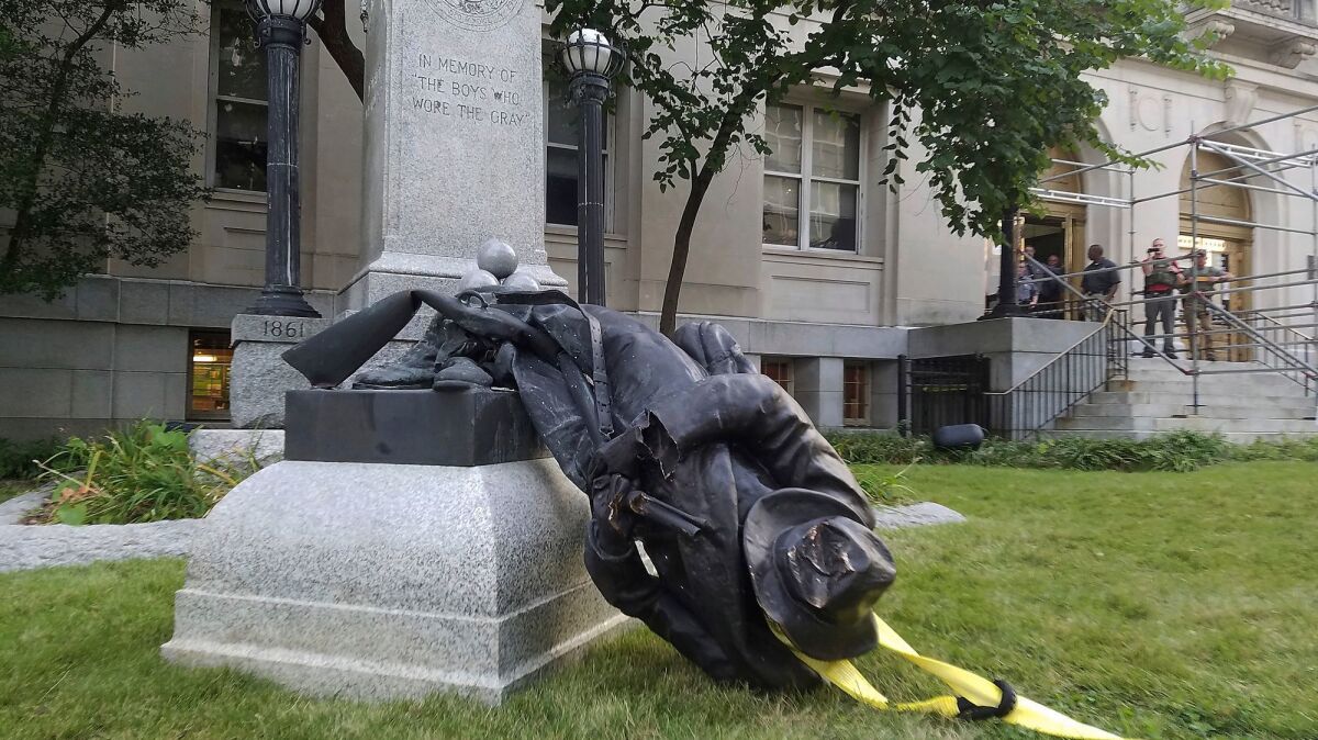 A toppled Confederate statue lies on the ground on Aug. 14, 2017, in Durham, N.C.