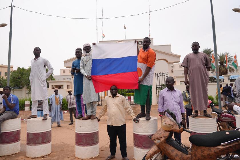 Supporters of mutinous soldiers hold a Russian flag as they demonstrate in Niamey, Niger, Thursday July 27 2023. Governing bodies in Africa condemned what they characterized as a coup attempt Wednesday against Niger's President Mohamed Bazoum, after members of the presidential guard declared they had seized power in a coup over the West African country's deteriorating security situation. (AP Photo/Sam Mednick)