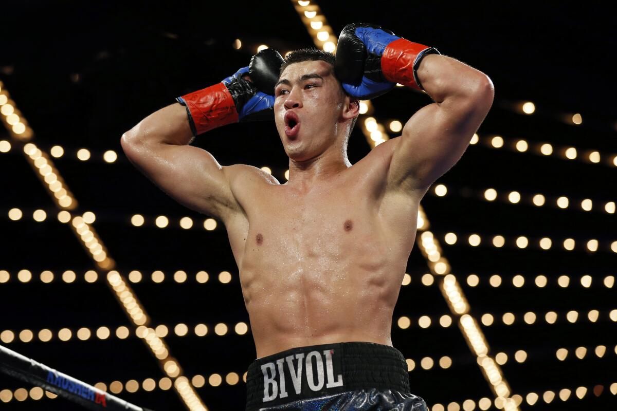 Dmitry Bivol celebrates defeating Sullivan Barrera in a WBA light heavyweight fight.