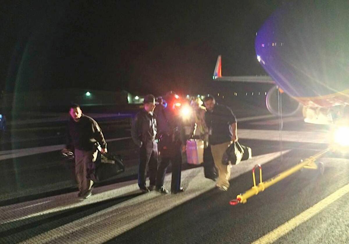 Passengers exit a Southwest Airlines flight Sunday that was supposed to land in Branson, Mo., but instead touched down in nearby Hollister. The crew realized the error shortly after landing, and the passengers were safely taken on to Branson. Both pilots are on leave pending an investigation.