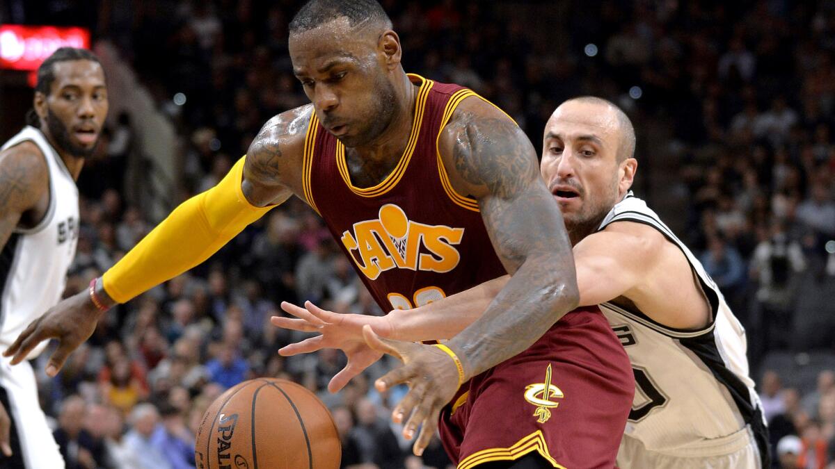 Cavaliers forward LeBron James is fouled by Spurs guard Manu Ginobili on a drive to the basket in the first half Thursday night.