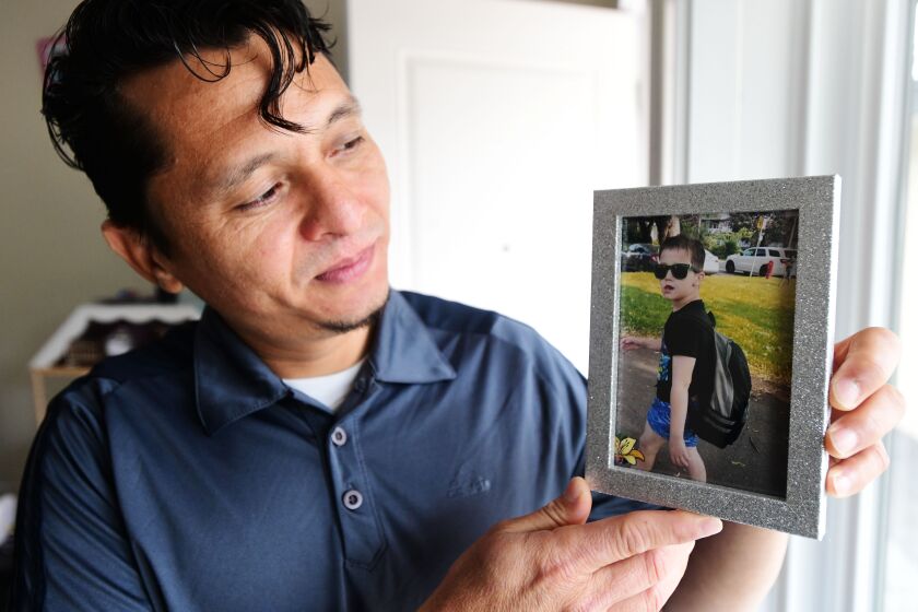 Carlos Rivera, holds up a photo of his son, Enrrique, 9, in his Surrey, BC, Canada, home May 6, 2021.