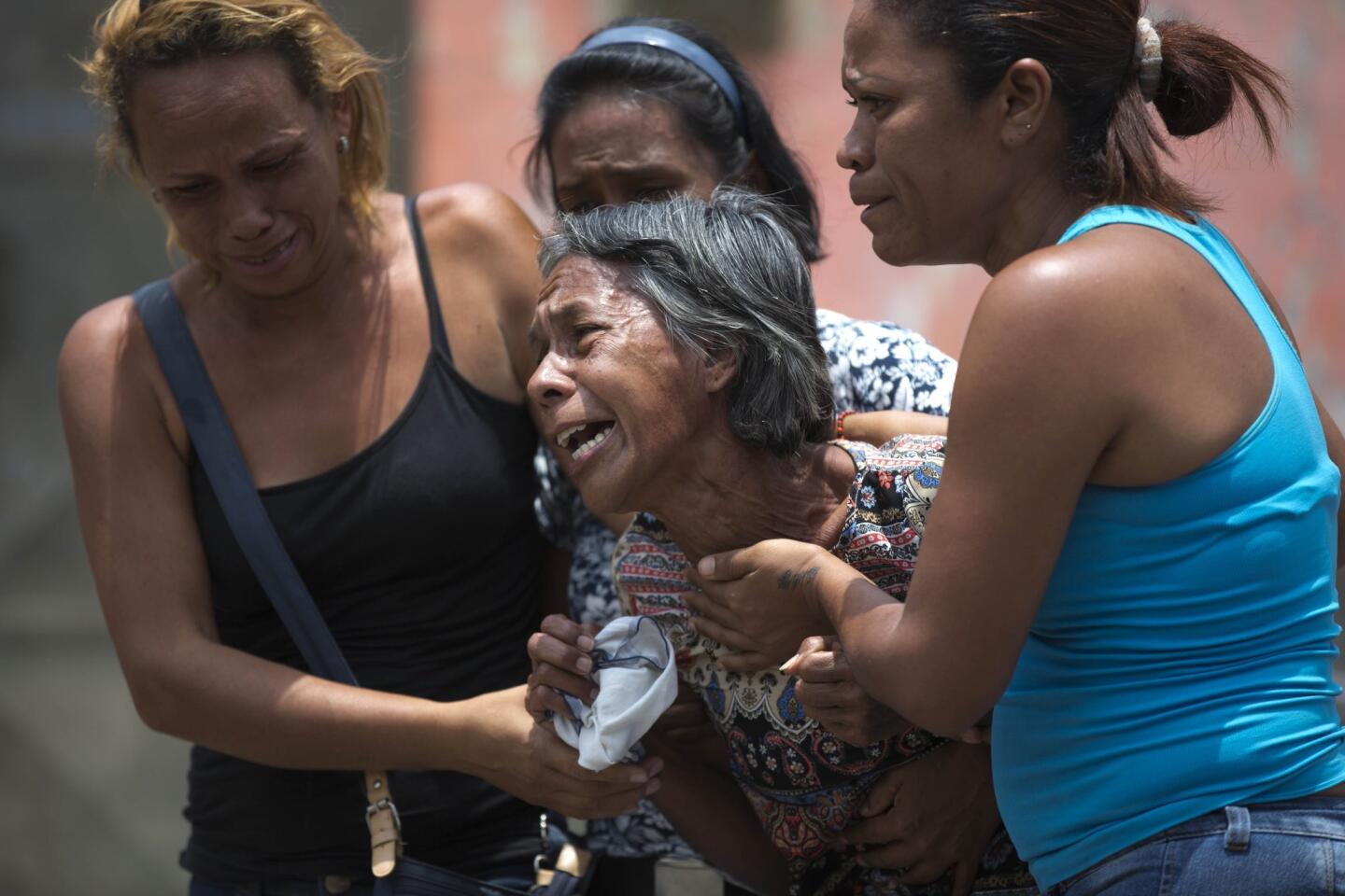 Relatives cry March 29 after learning their loved ones died in a fast-moving fire a day prior that swept through a police station where prisoners were being kept in crowded cells in Valencia, Venezuela.