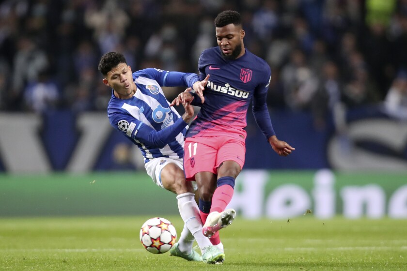 Porto's Evanilson vies for the ball with Atletico Madrid's Thomas Lemar, right, during the Champions League Group B soccer match between FC Porto and Atletico Madrid at the Dragao stadium in Porto, Portugal, Tuesday, Dec. 7, 2021. (AP Photo/Luis Vieira)