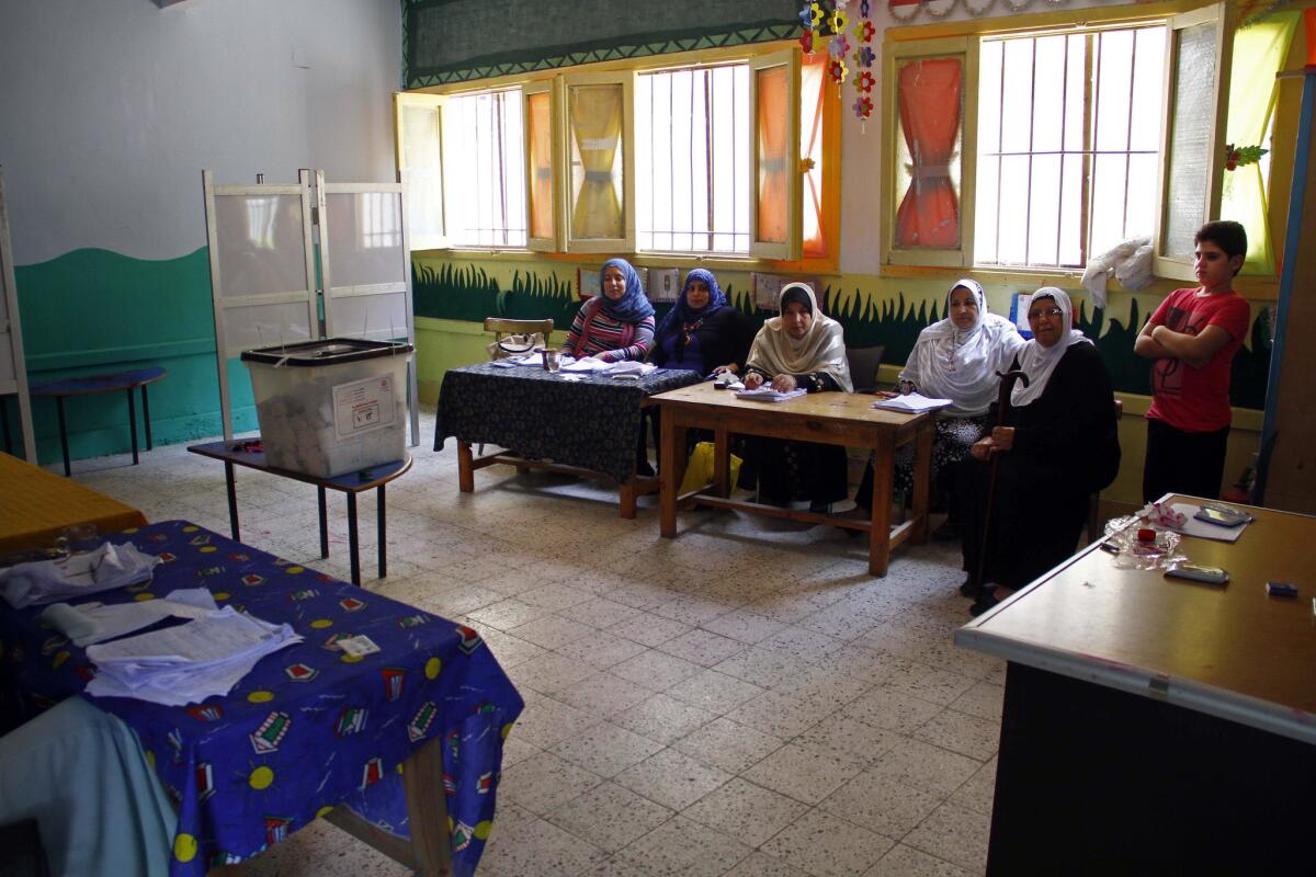 Egyptian election workers wait for voters at a polling station in Suez.