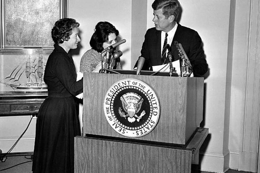 Correspondents Helen Thomas, center, of UPI and Frances Lewine of the Associated Press ask President Kennedy for copies of his announcement pledging federal help to quell rioting in Birmingham, Ala., in 1963. Thomas went to the White House at a time when female reporters were largely expected to write about the first lady's social calendar, fashion and manners.