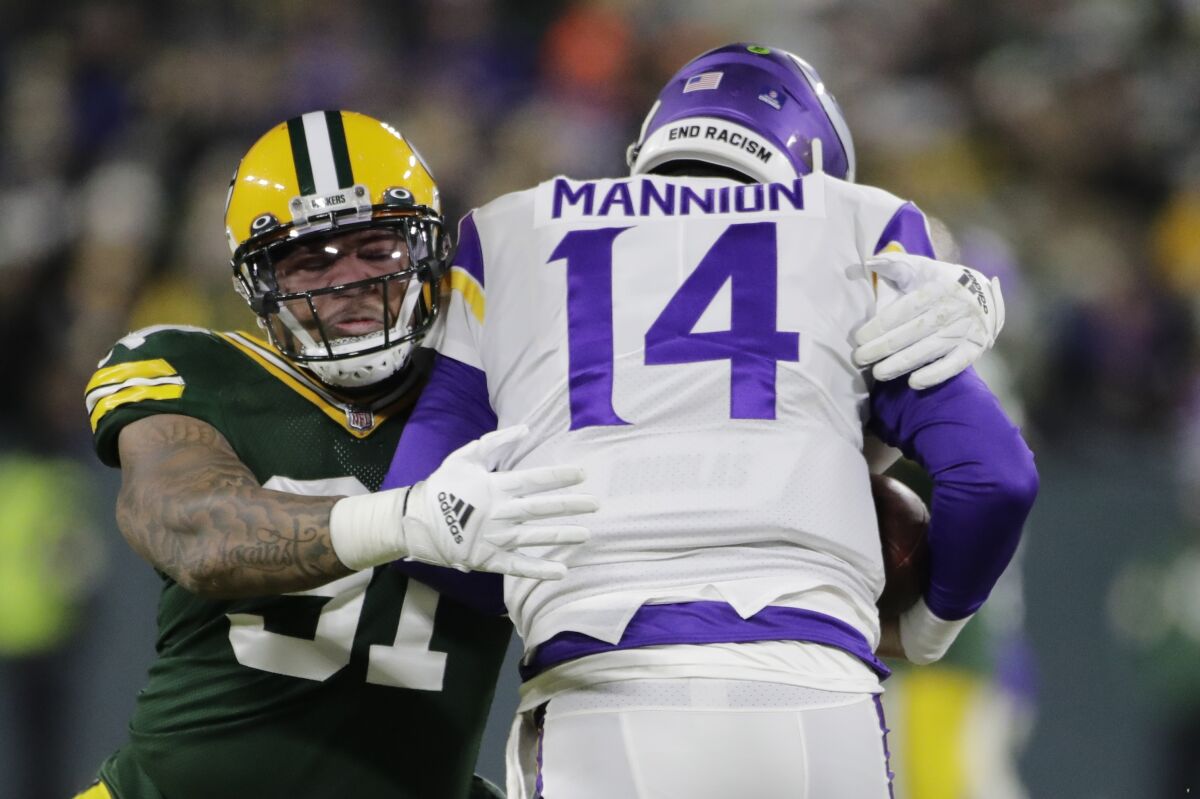 Green Bay Packers' Preston Smith sacks Minnesota Vikings' Nate Stanley during the first half of an NFL football game Sunday, Jan. 2, 2022, in Green Bay, Wis. (AP Photo/Aaron Gash)