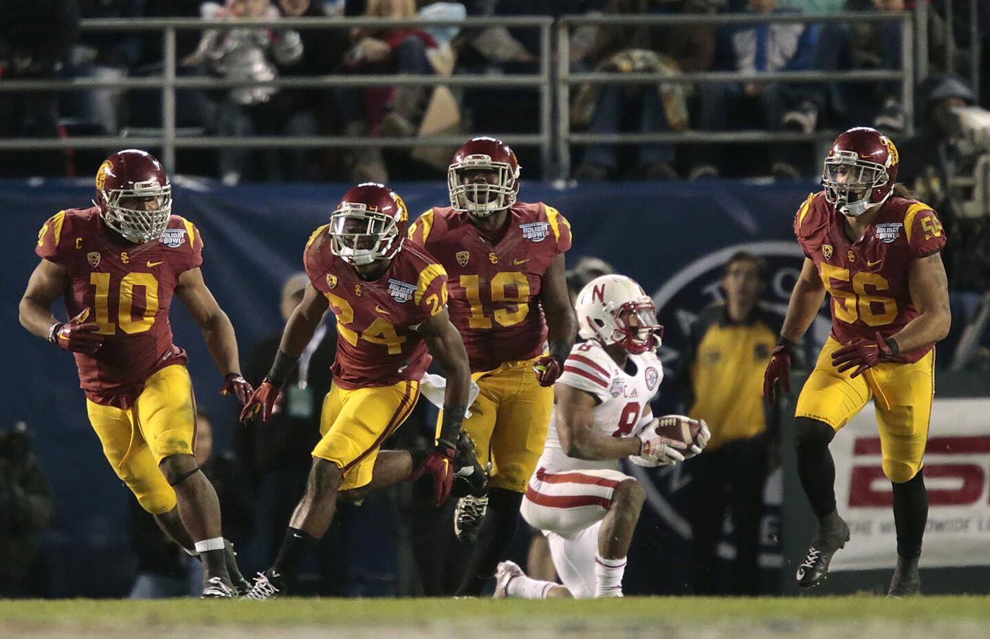 USC players celebrate after defensive back Leon McQuay (24) stopped Nebraska running back Ameer Abdullah behind the line of scrimmage on a fourth-down play with 2 1/2 minutes left in the fourth quarter.