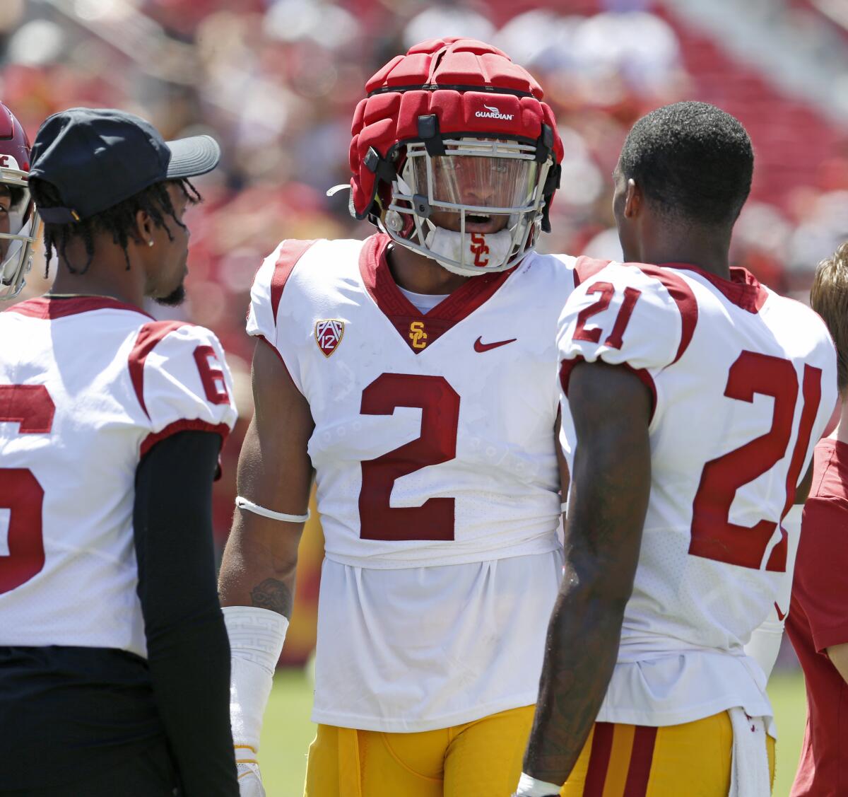 USC defensive end Romello Height speaks with Mekhi Blackmon, left, and Latrell McCutchin.