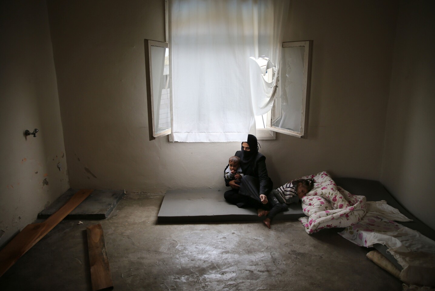 ARCHIVO - En esta fotografía de archivo del 23 de octubre de 2015, la refugiada siria Hind Salem, que huyó con su familia de la ciudad de Palmira en el centro de Siria debido a los bombardeos rusos, se sienta en el piso con sus hijos en su vivienda sin muebles, en la ciudad de Reyhanli, en la frontera turco-siria, en el sur de Turquía. "Para nada teníamos intención de salir de nuestro país. Pero los bombardeos rusos nos hicieron irnos", señaló. Un nuevo informe de un grupo defensor de los derechos humanos acusa a Rusia de utilizar municiones de racimo y bombas no dirigidas sobre áreas civiles en Siria en ataques que dice han provocado la muerte de cientos de personas. El informe de Amnistía Internacional difundido el miércoles 23 de diciembre de 2015 indica que ha habido un aumento en los reportes del uso de municiones de racimo en áreas blanco de las fuerzas rusas desde que Moscú ingresó formalmente al conflicto el 30 de septiembre. (Foto AP/Hussein Malla, archivo)