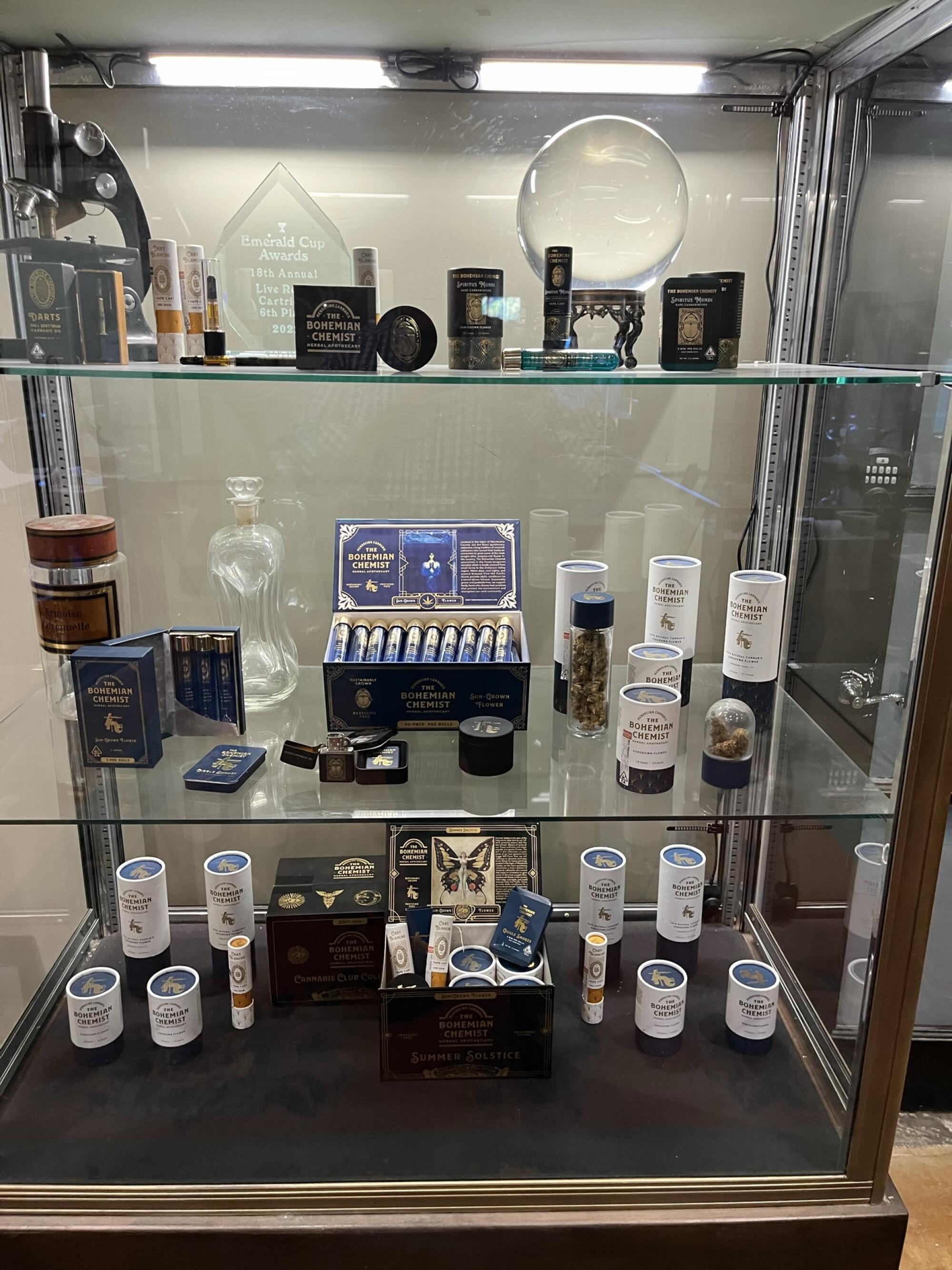 A glass cabinet filled with apothecary equipment and cannabis products
