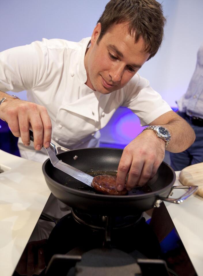 Chef Richard McGeown cooks a lab-grown beef patty during a public taste test in London on Monday.