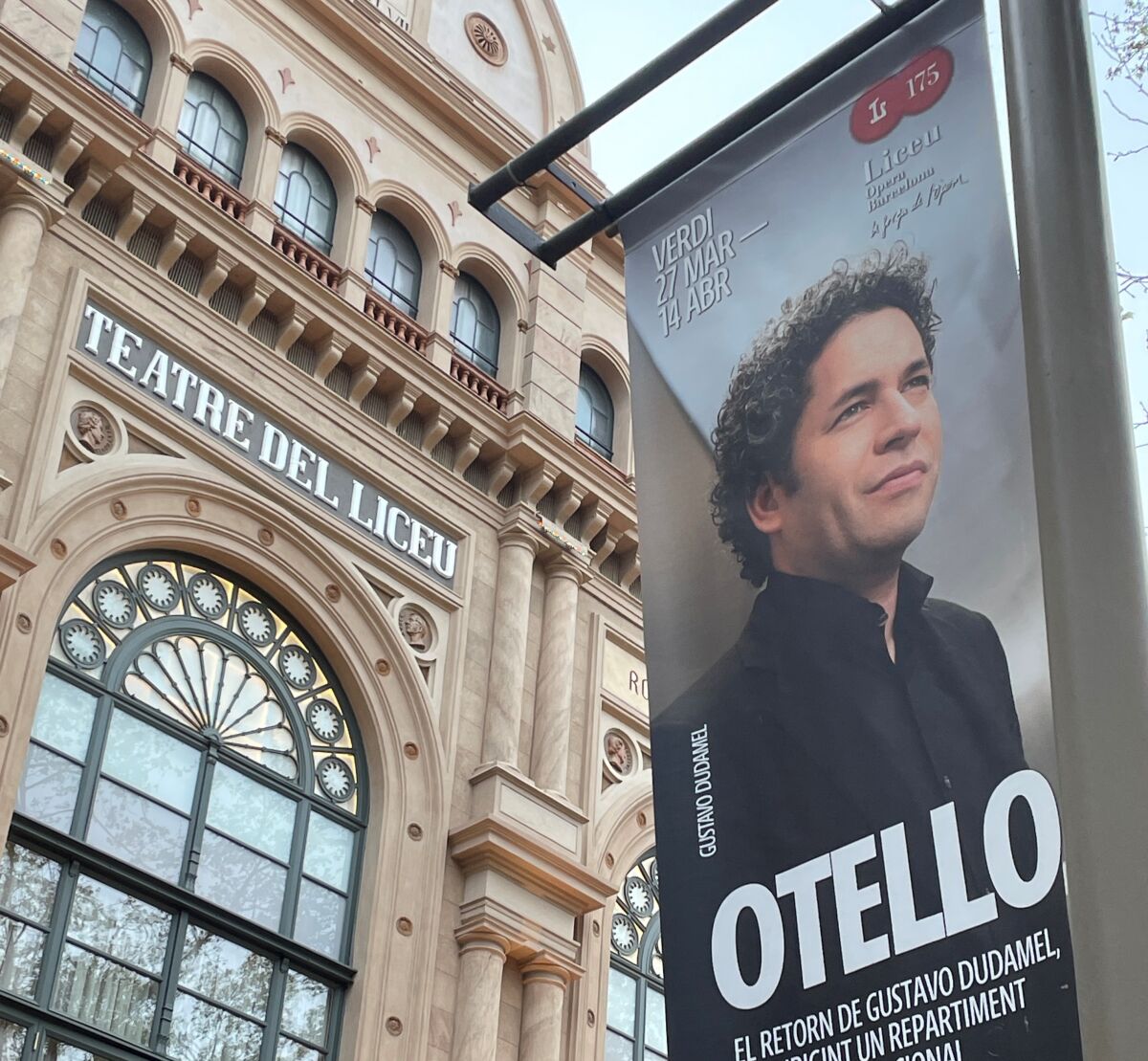 An "Otello" banner hangs outside the ornate windows and columns of a theater.