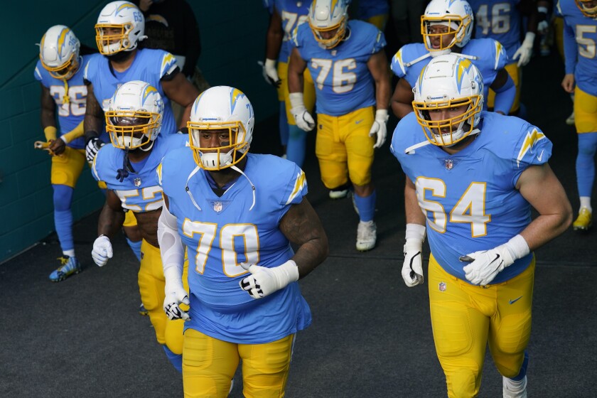 Trai Turner (70) leads the Chargers out of the SoFi Stadium tunnel.