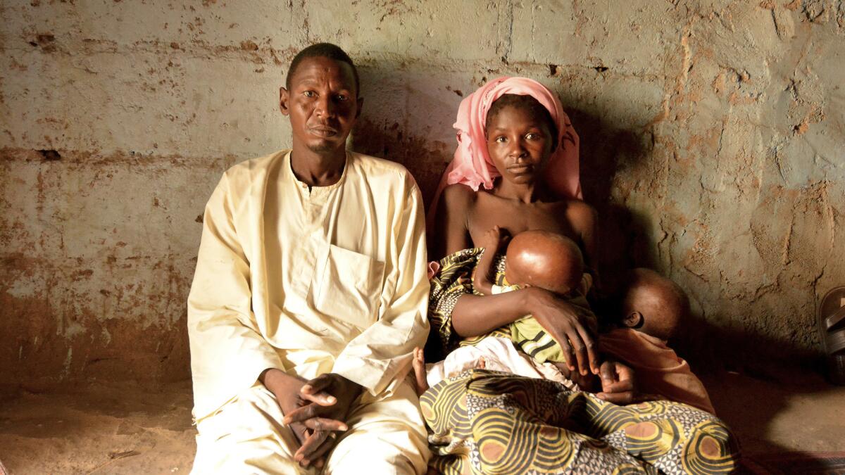 Saleh Umar and his wife, Hadiza Adamu, with their 1-year-old twins. The couple are desperately worried about the boy, Hassan, who has acute malnutrition.