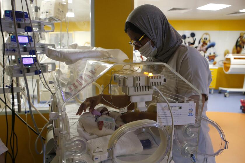 A Moroccan nurse takes care of one of the nine babies protected in an incubator at the maternity ward of the private clinic of Ain Borja in Casablanca, Morocco, Wednesday, May 5, 2021. A Malian woman gave birth to nine babies after n ' to have waited only seven, announced Wednesday the Ministry of Health of Mali. . Halima CissÈ, 25, gave birth by caesarean section Tuesday in Morocco after being sent there for special care, the ministry said. (AP Photo / Abdeljalil Bounhar)