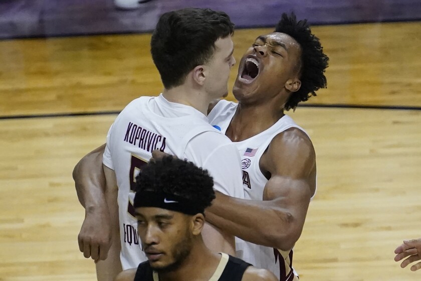Florida State center Balsa Koprivica, left, gets a hug from teammate Scottie Barnes after a dunk.