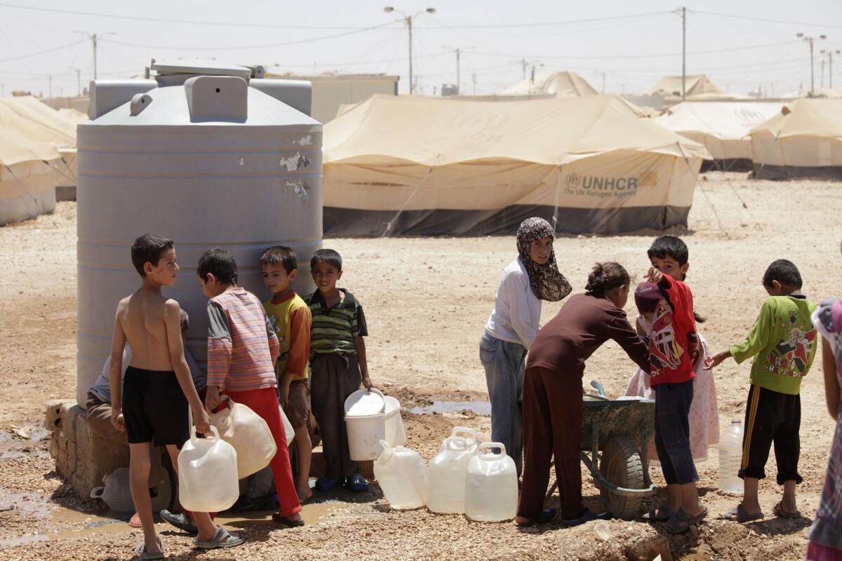 Syrian refugees fill up their water jugs at the Zaatari refugee camp near the Syrian border in Mafraq, Jordan. Zaatari is home to about 120,000 Syrians.
