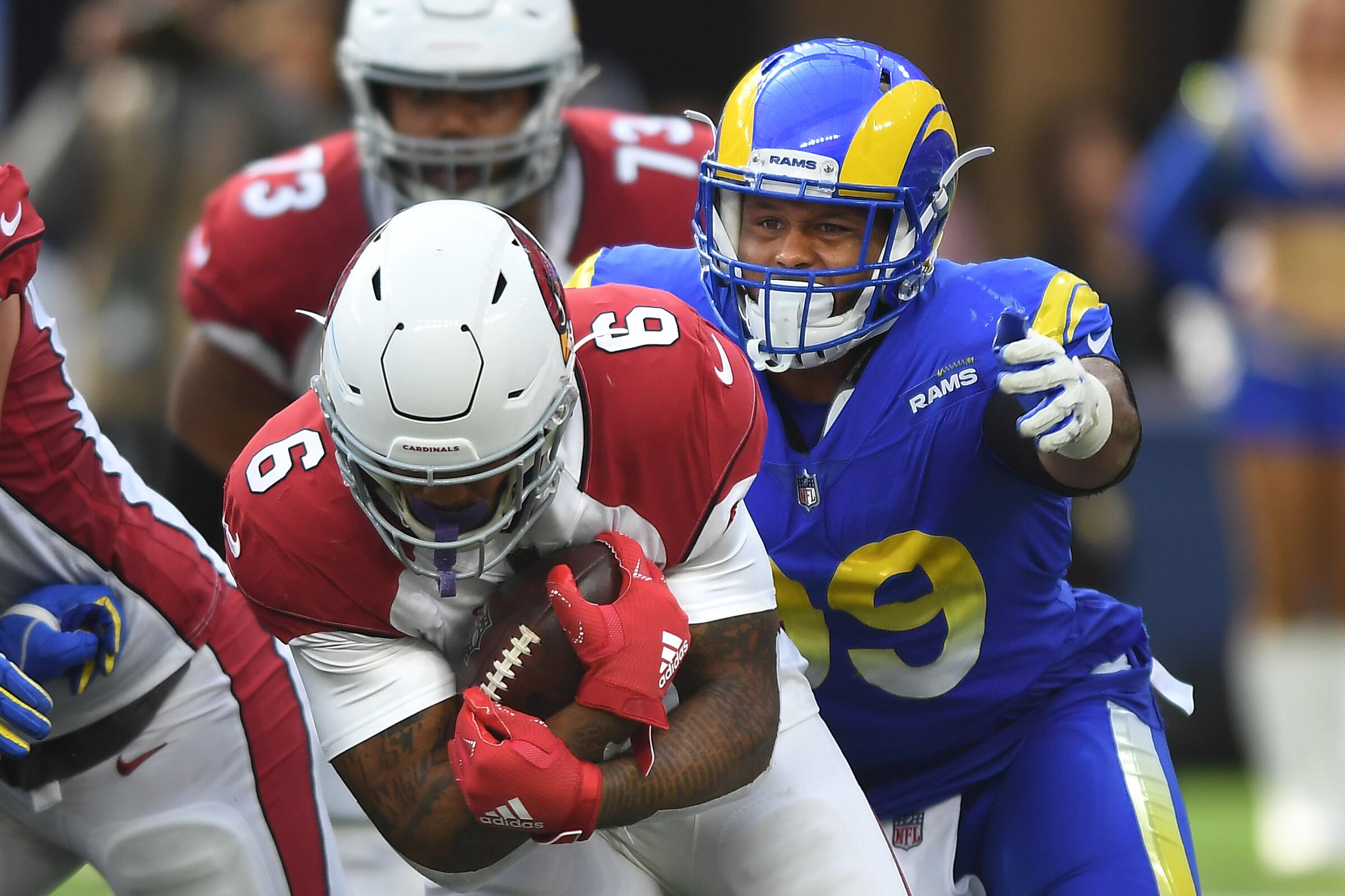 Rams defensive tackle Aaron Donald, right, tries to wrap up Cardinals running back James Conner.