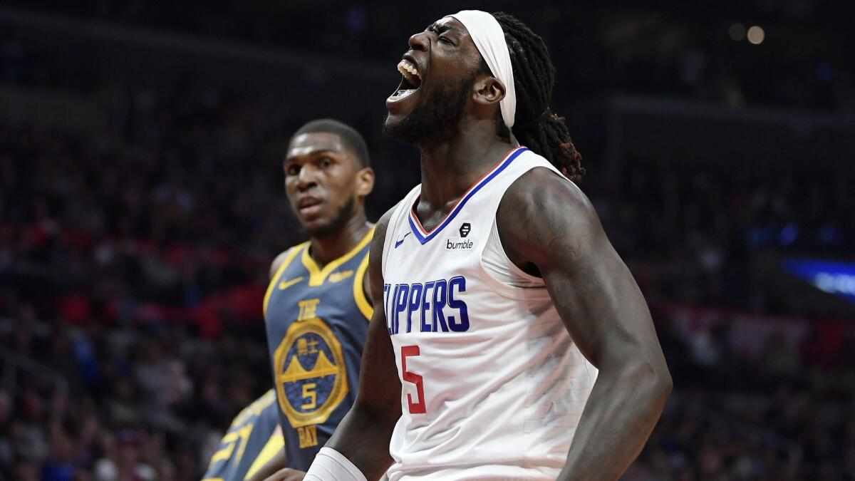 Clippers forward Montrezl Harrell, right, celebrates after scoring as Golden State Warriors forward Kevon Looney watches during the second half.