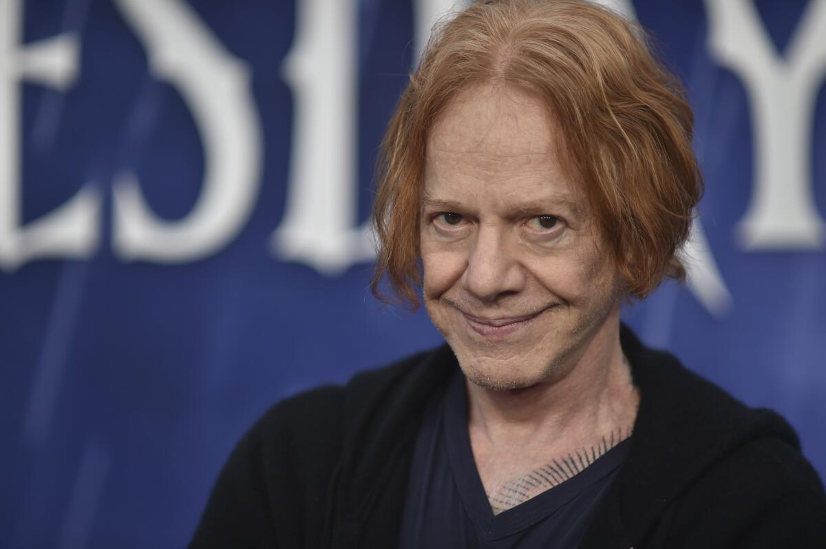 Danny Elfman has red hair with dark eyes and a smile.