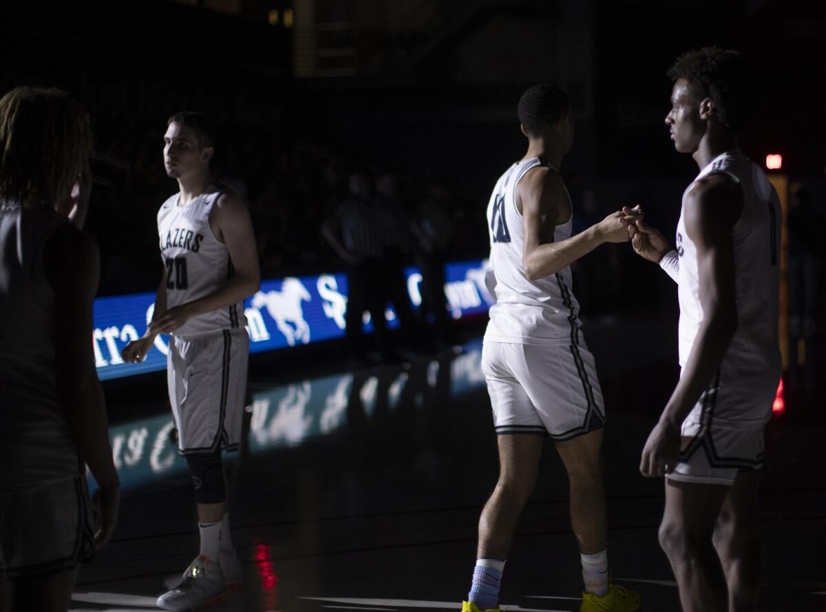 Sierra Canyon guard Bronny James, right, looks on during introductions before a game against Windward at Cal State Northridge on Jan. 23.