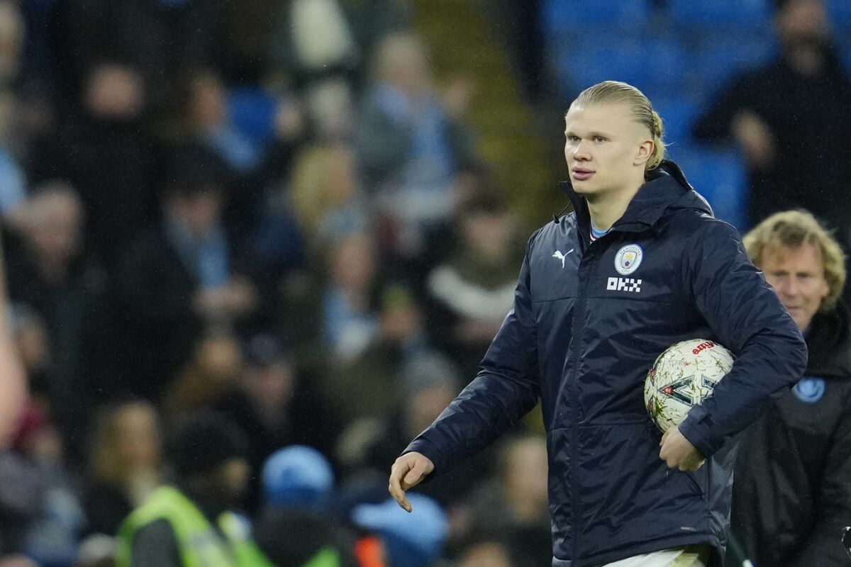 Manchester City's Erling Haaland holds the ball at the end of the English FA Cup quarter final soccer match between Manchester City and Burnley at the Etihad stadium in Manchester, England, Saturday, March 18, 2023. (AP Photo/Jon Super)