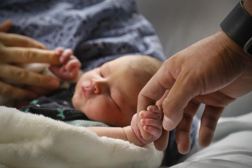 SAN DIEGO, CA: April 25, 2017 | Trisha Bernal left, and her husband, Gustavo Bernal, right, hold the hands of their newborn son, Malachi, who was born Monday, April 24, at the Kaiser Permanente Zion Medical Center in Grantville before being moved to the new Kaiser Permanente San Diego Medical Center on Clairemont Mesa Boulevard, on Tuesday, the first day the new hospital began accepting patients. | Photo by Howard Lipin/San Diego Union-Tribune/Mandatory Credit: HOWARD LIPIN SAN DIEGO UNION-TRIBUNE/ZUMA PRESS