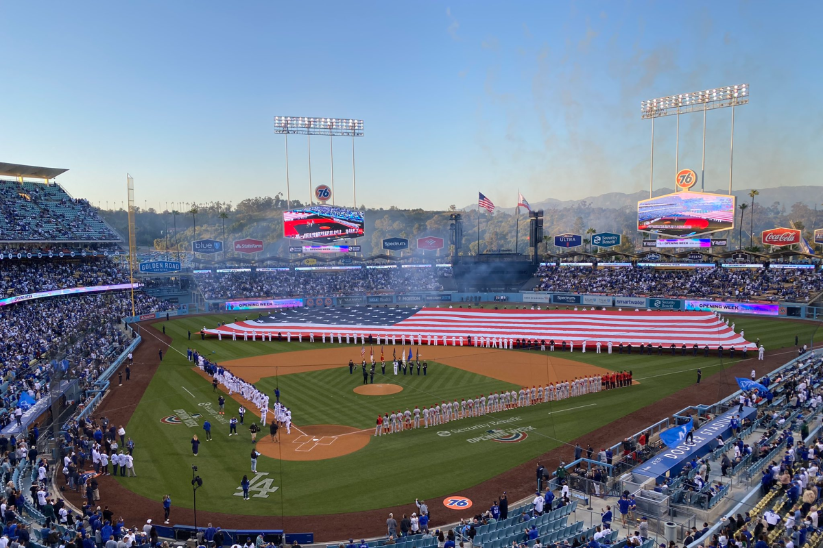 A giant American flag covers the field at Dodger Stadium before the start of the Dodgers' home opener.