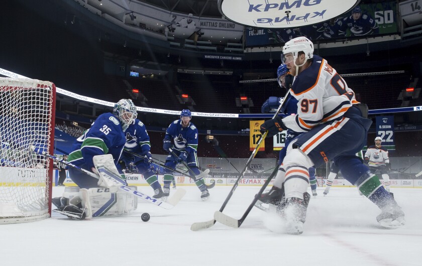 Vancouver Canucks goalie Thatcher Demko (35) stops Edmonton Oilers' Connor McDavid (97) during the second period of an NHL hockey game, Tuesday, May 4, 2021 in Vancouver, British Columbia. (Darryl Dyck/The Canadian Press via AP)
