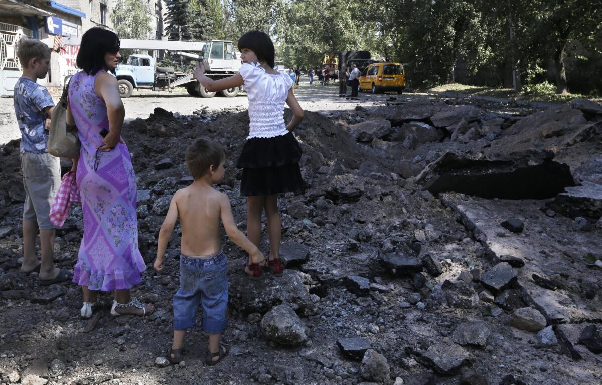 As shelling and gunfire exchanges between Ukrainian troops and pro-Russia gunmen close in on Donetsk, as in this residential area on Wednesday, concerns are mounting that Russian President Vladimir Putin might invade Ukraine under the pretext of aiding the Russian-speaking communities.