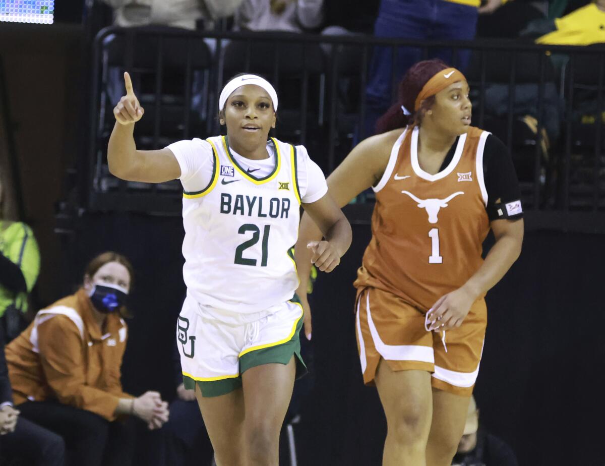 Baylor guard Ja'Mee Asberry, left, reacts to her three point play over Texas center Lauren Ebo (1) in the first half of an NCAA college basketball game, Friday, Feb. 4, 2022, in Waco, Texas. (Rod Aydelotte/Waco Tribune-Herald via AP)