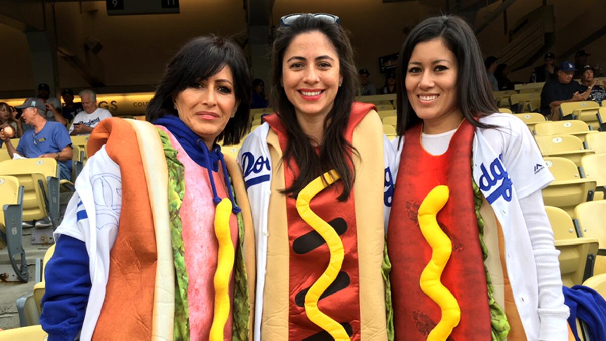 Cathy Shapiro, left, Genevieve Diaz and Juliet Diaz take their seats at Dodger Stadium on Tuesday.