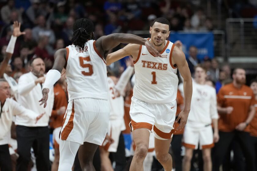 Texas forward Dylan Disu (1) celebrates with teammate guard Marcus Carr (5) after making a basket in the second half of a second-round college basketball game against Penn State in the NCAA Tournament, Saturday, March 18, 2023, in Des Moines, Iowa. (AP Photo/Charlie Neibergall)