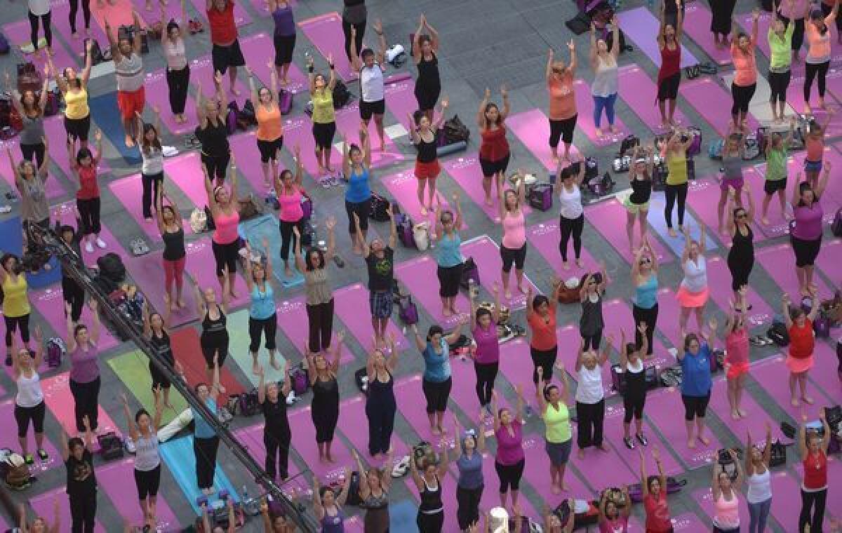 Participants practice yoga as part of a series of mass yoga classes set on Times Square to celebrate the summer solstice, in New York, on Friday.