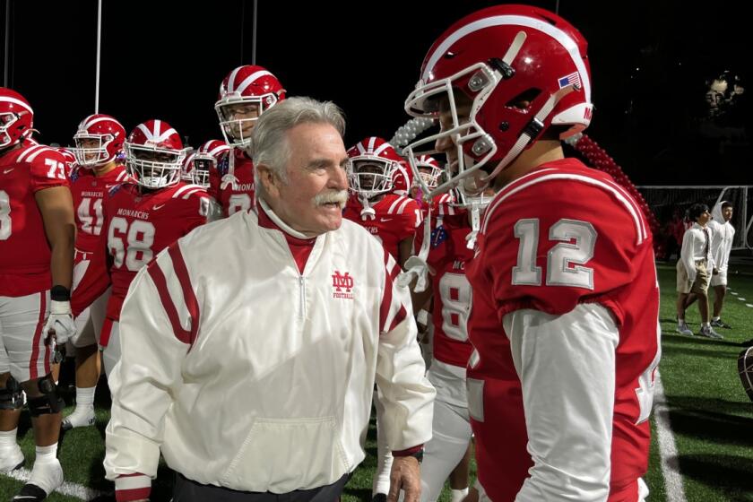 Mater Dei coach Bruce Rollinson speaks to quarterback Elijah Brown before Friday's playoff game against JSerra.