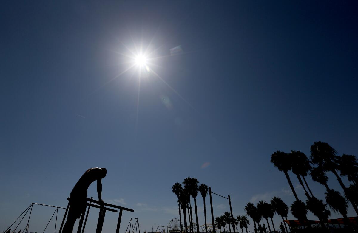 A man pauses from working out under the hot sun on Santa Monica Beach on Saturday.